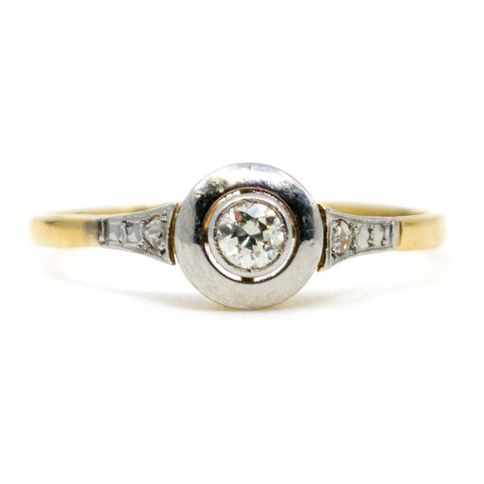 A solitaire diamond ring with diamond shoulders in yellow gold and platinum