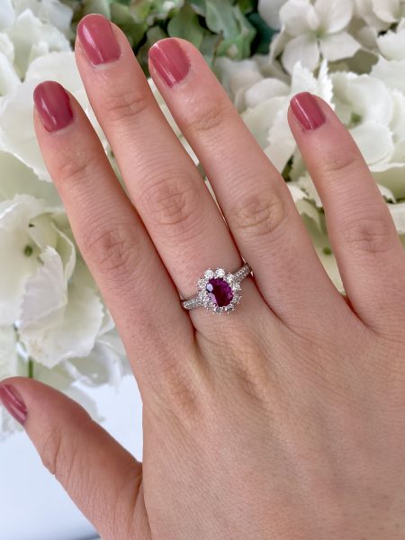 Burma Ruby and Diamond Cluster Ring in Platinum; 1.16 carat oval faceted Burmese ruby claw set within a diamond surround, with two rows of diamonds set into each shoulder