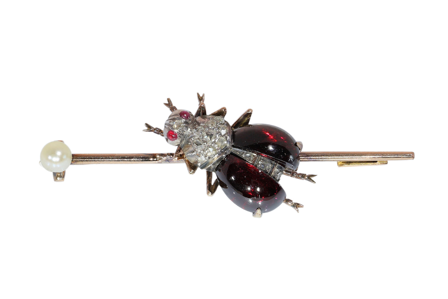 An antique gold bar brooch with a diamond, garnet and ruby set insect in the centre