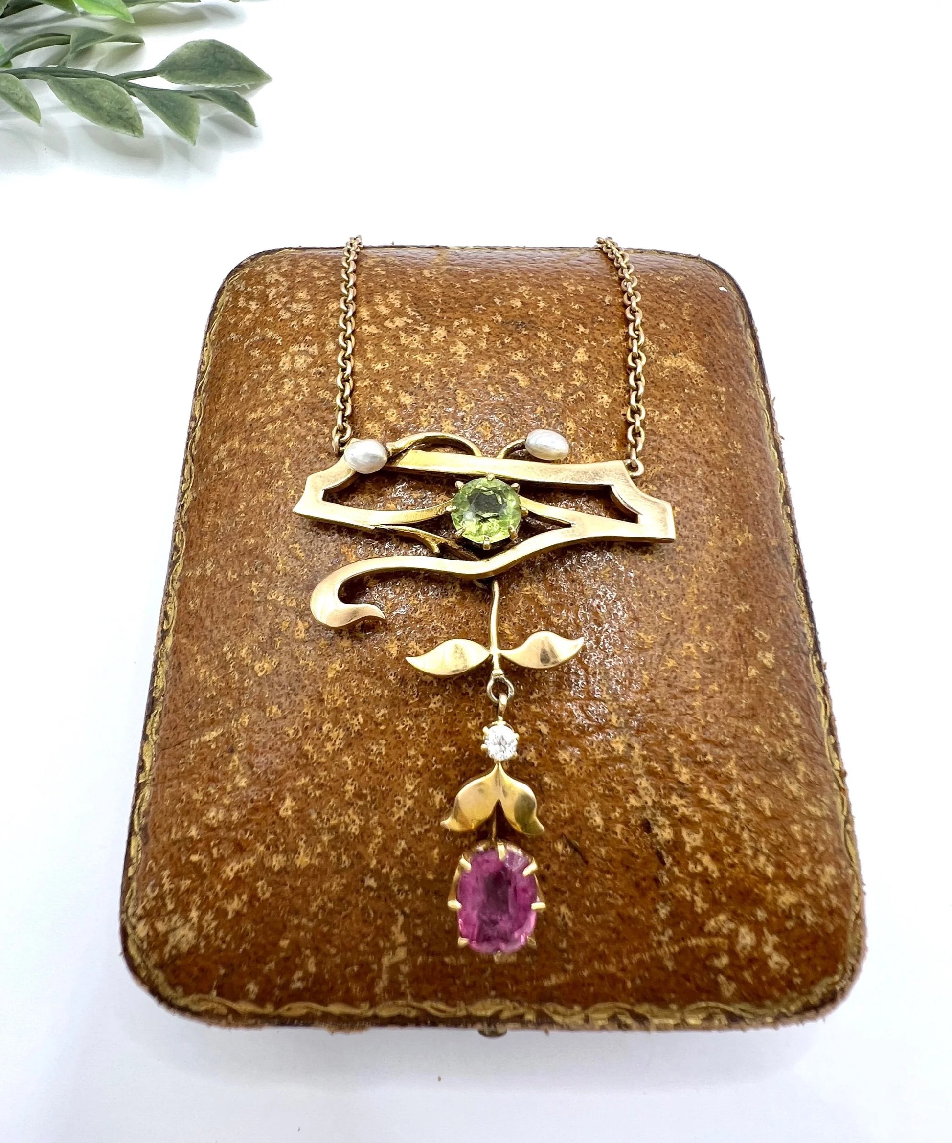 A yellow gold pendant necklace with pearls, a peridot, a diamond and a pink tourmaline drop