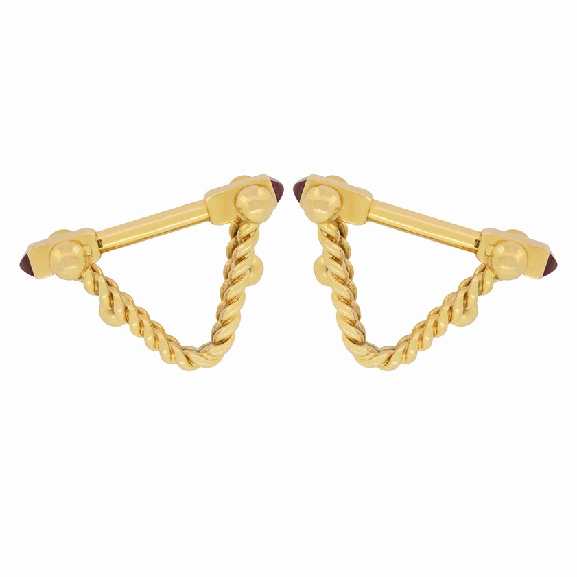 A pair of yellow gold ruby cufflinks, on a white background