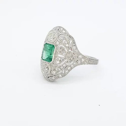 Colombian Emerald, Diamond and Platinum Openwork Plaque Ring; studded with diamonds surrounding an emerald-cut emerald