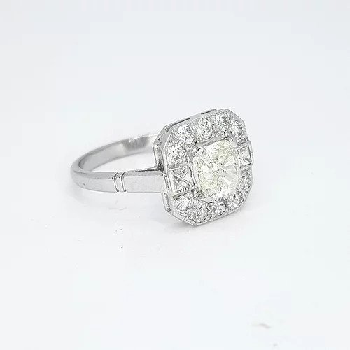 1.03ct Radiant Cut Diamond Cluster Ring; radiant cut diamond surrounded by a halo of diamonds which is accented by square princess-cut diamonds to the shoulders and completed by round-cut diamonds, in 18ct white gold