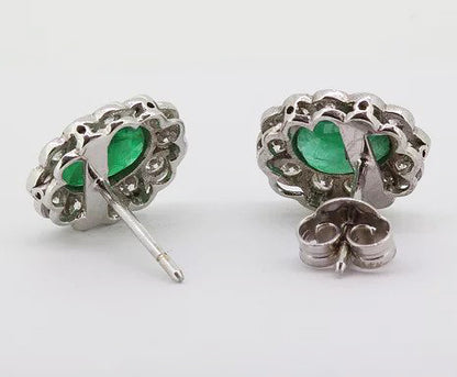 Emerald and Diamond Oval Cluster Stud Earrings; 1.66cts oval faceted emeralds surrounded by 0.80cts sparkling diamonds, in 18ct white gold