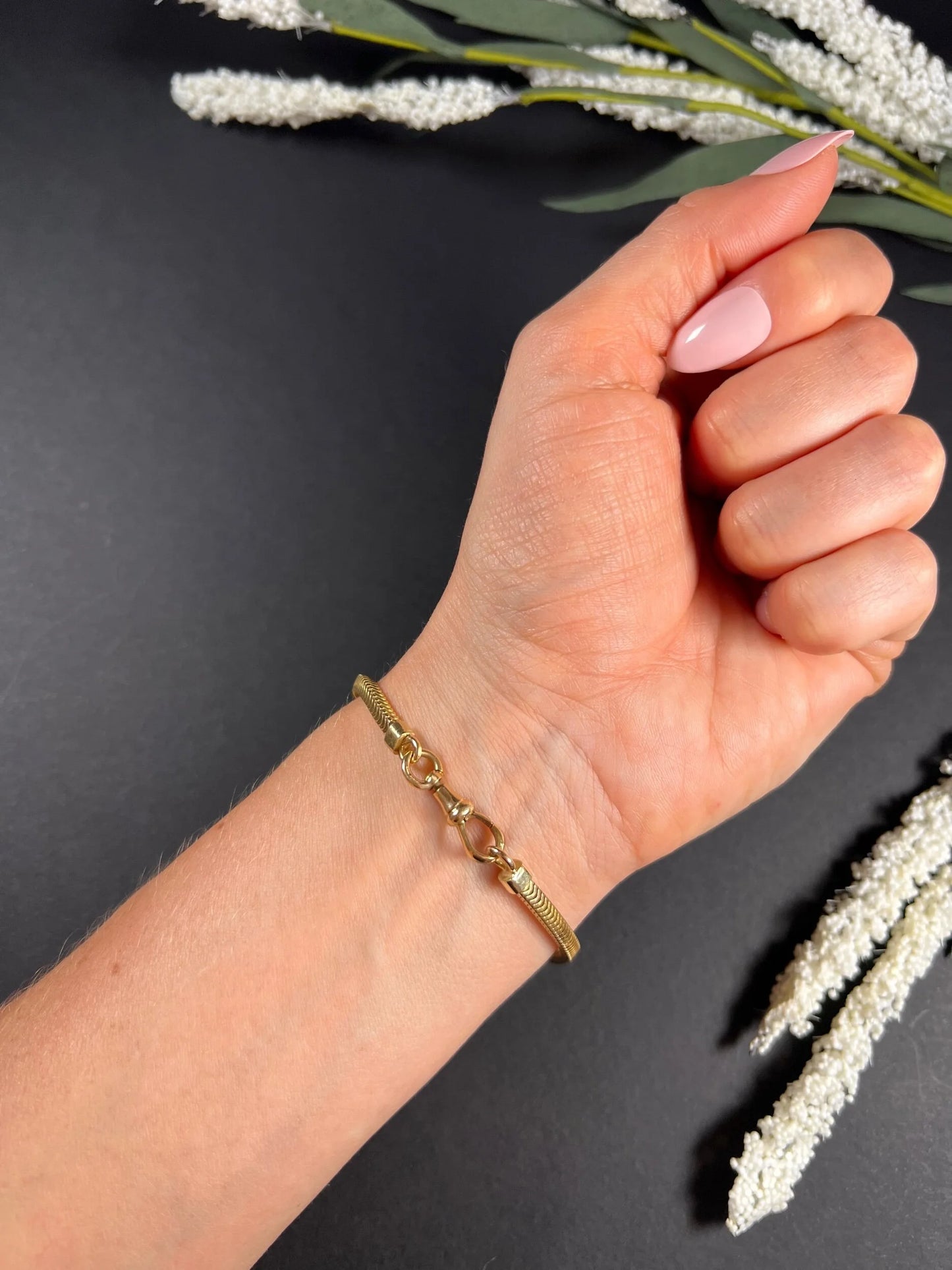 A yellow gold snake link bracelet, modelled on a wrist