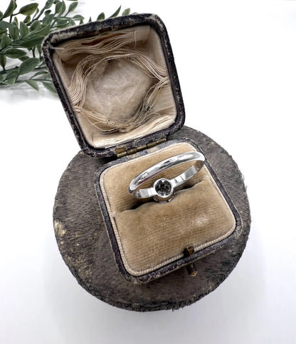 A solitaire round diamond ring in white gold, in an antique ring box