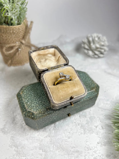 A two stone diamond crossover ring in yellow and white gold, in a ring box