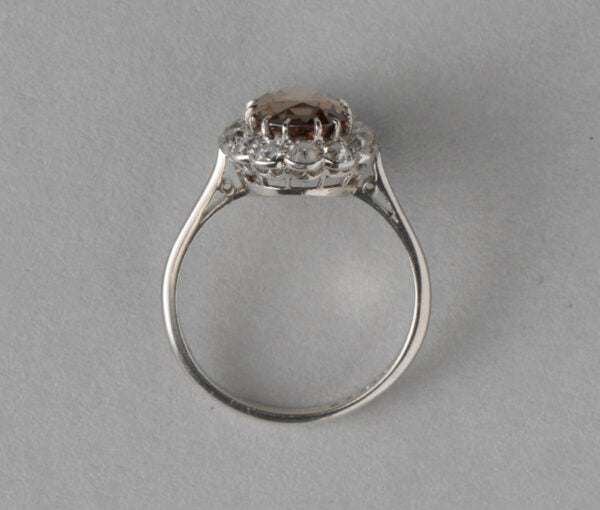 Antique Edwardian Zircon, Old Cut Diamond and Platinum Oval Cluster Ring; 2.27ct brown oval faceted zircon surrounded by 0.89cts old cut diamonds