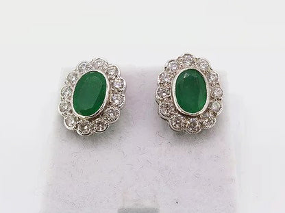 Emerald and Diamond Oval Cluster Stud Earrings; 1.66cts oval faceted emeralds surrounded by 0.80cts sparkling diamonds, in 18ct white gold