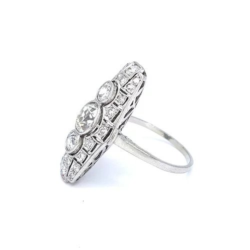 Art Deco Diamond and Platinum Three Stone Cluster Plaque Ring; featuring three brilliant cut diamonds in vertical formation surrounded by smaller circular diamonds, set in a pierced platinum mount with millegrain edging