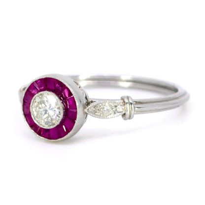 A brilliant cut diamond and french cut ruby halo target cluster ring in platinum