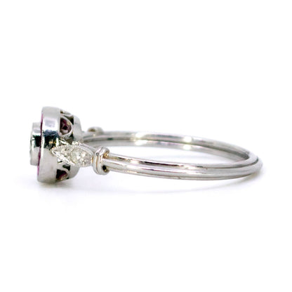 A brilliant cut diamond and french cut ruby halo target cluster ring in platinum