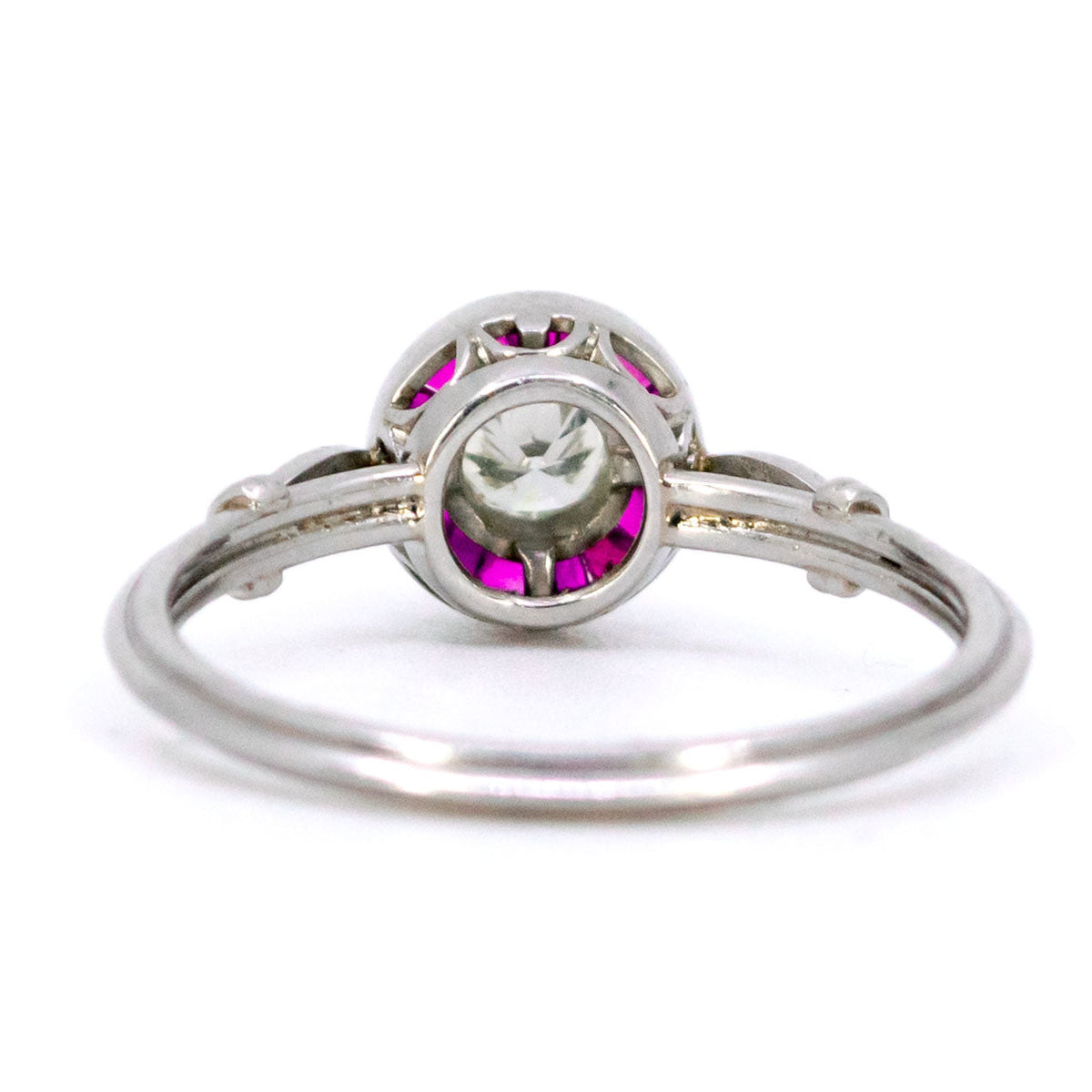 A brilliant cut diamond and french cut ruby halo target cluster ring in platinum