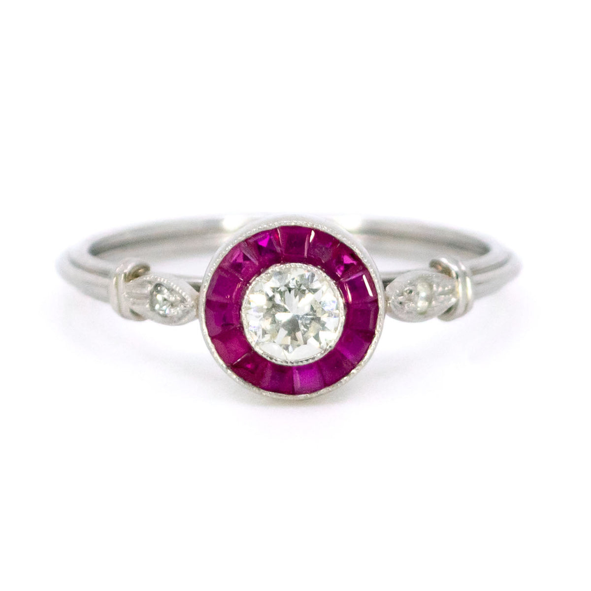 A brilliant cut diamond and french cut ruby halo target cluster ring in platinum