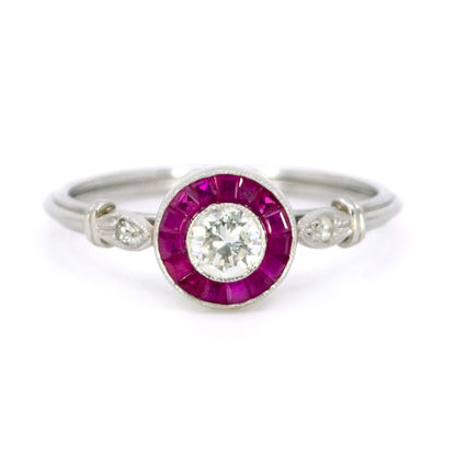 A brilliant cut diamond and french cut ruby halo target cluster ring in platinum