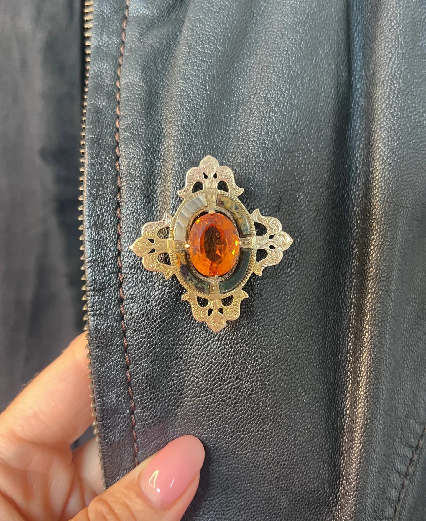 A yellow gold, oval citrine and agate ornate brooch, modelled on a black jacket
