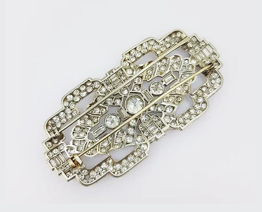 Antique Diamond and Platinum Brooch; A beautiful brooch crafted from platinum, the open-work design set with baguette-cut and circular-cut diamonds.