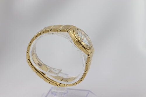 Omega Constellation Double Eagle 18ct Yellow Gold Ladies 25mm Quartz Watch, 11897500, diamond bezel and hour markers, white mother of pearl dial, 18ct Yellow Gold bracelet with a double-fold hidden clasp, with original Omega box and papers.