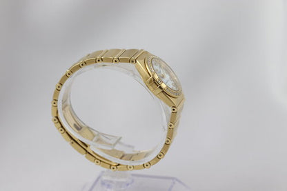 Omega Constellation Double Eagle 18ct Yellow Gold Ladies 25mm Quartz Watch, 11897500, diamond bezel and hour markers, white mother of pearl dial, 18ct Yellow Gold bracelet with a double-fold hidden clasp, with original Omega box and papers.