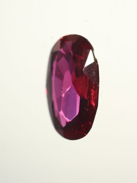 Vintage Ruby and Diamond Cluster Ring; featuring an 0.80ct oval faceted ruby surrounded by 1.80cts round brilliant-cut diamonds, in 18ct white gold. Circa 1970s