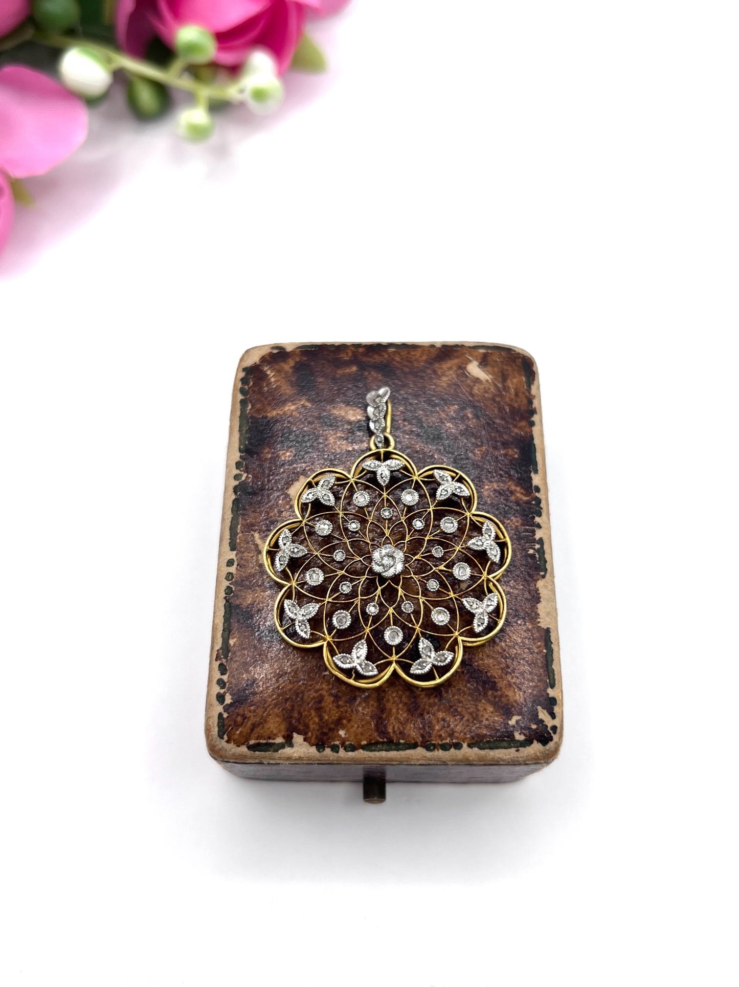 A floral openwork diamond pendant in gold and platinum, in an antique box