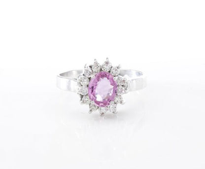 Vintage Pink Sapphire and Diamond Oval Cluster Ring; central 1.00ct oval pink sapphire surrounded by 0.39cts round brilliant-cut diamonds, in 18ct white gold. Circa 1970s