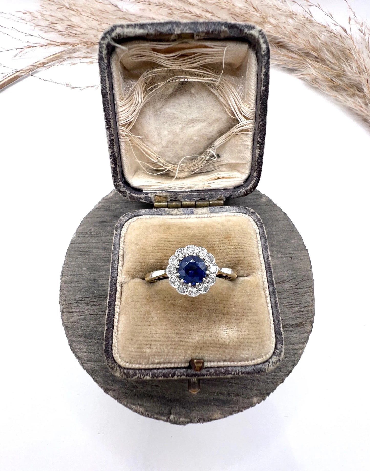 A sapphire and diamond flower cluster ring in yellow gold and platinum, in a ring box