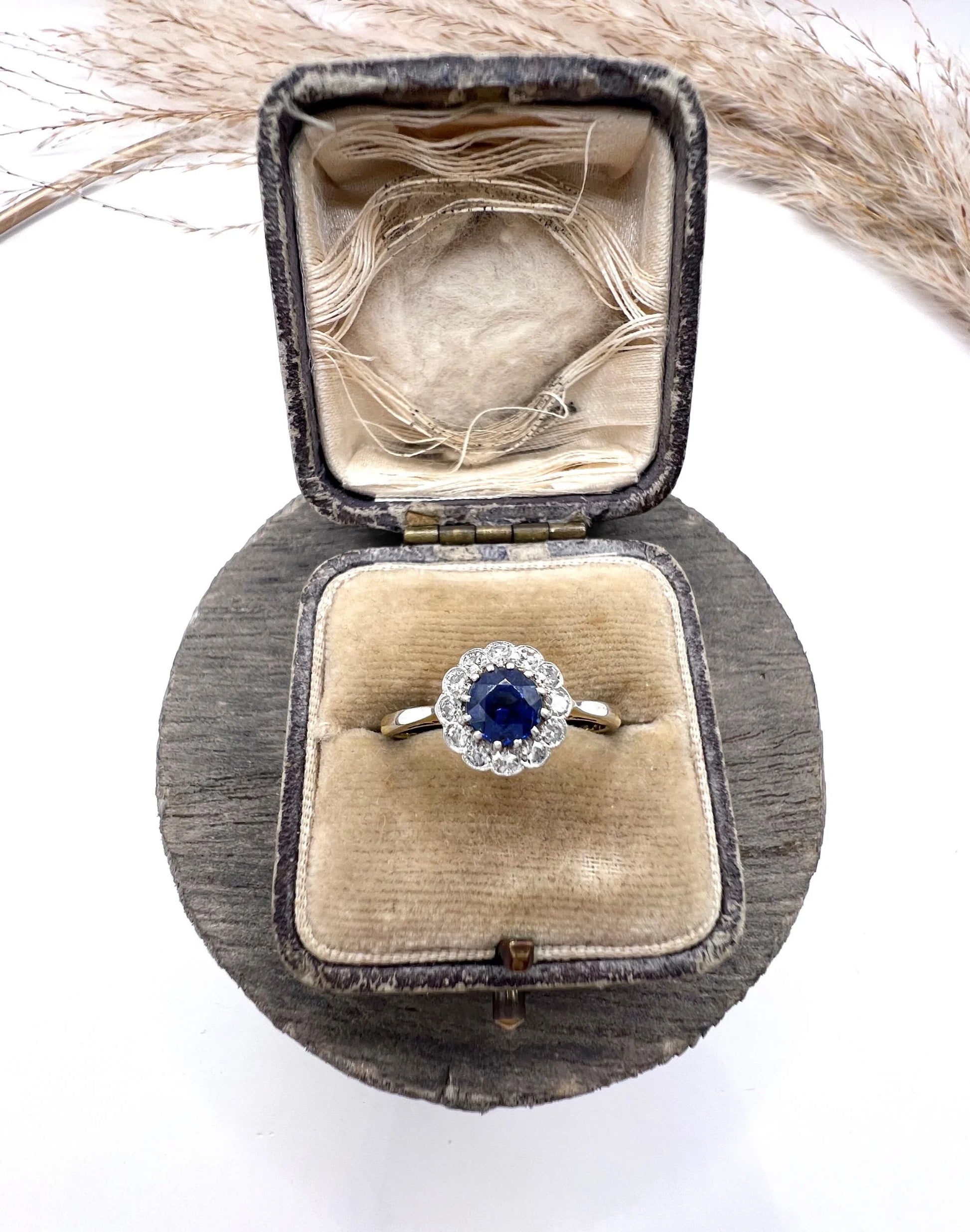 A sapphire and diamond flower cluster ring in yellow gold and platinum, in a ring box