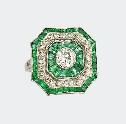 Art Deco Style Emerald and Diamond Cluster Square Cocktail Ring; brilliant diamond surrounded by borders of mixed cut emeralds and diamonds, in platinum. 
