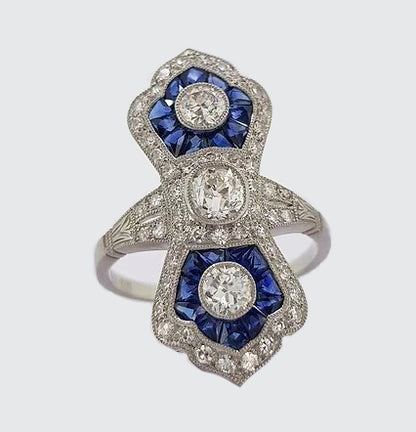 Art Deco Style Sapphire and Diamond Navette Panel Ring; navette-shaped ring set with brilliant-cut diamonds and calibre-cut sapphires. Mounted in platinum.