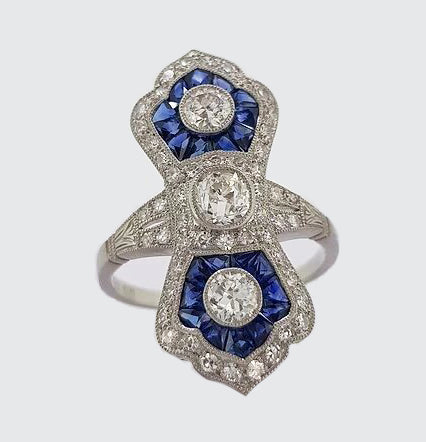 Art Deco Style Sapphire and Diamond Navette Panel Ring; navette-shaped ring set with brilliant-cut diamonds and calibre-cut sapphires. Mounted in platinum.