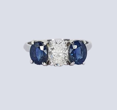 Sapphire and Diamond Three Stone Ring, classic trilogy ring featuring, 0.75ct oval-cut diamond flanked by 1.75cts oval sapphires, claw set, 18ct white gold.