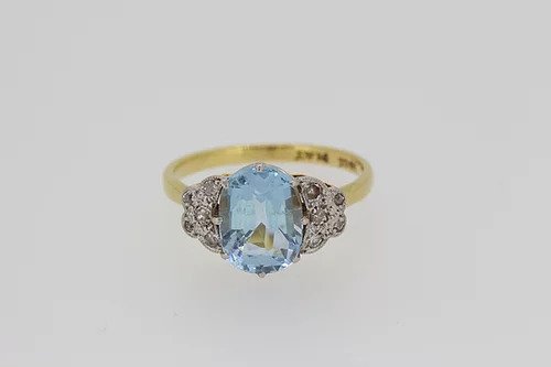 Vintage Aquamarine and Diamond Ring; oval faceted aquamarine flanked by diamonds, on a plain 18ct yellow gold shank, Circa 1960s
