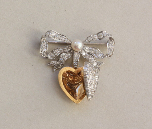 Antique Edwardian Diamond and Pearl Bow and Heart Locket Brooch; set with 1.08cts old-cut diamonds and a natural pearl, platinum and 18ct gold