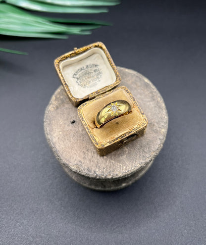 A single stone old cut diamond gypsy band ring in yellow gold, in an antique ring box