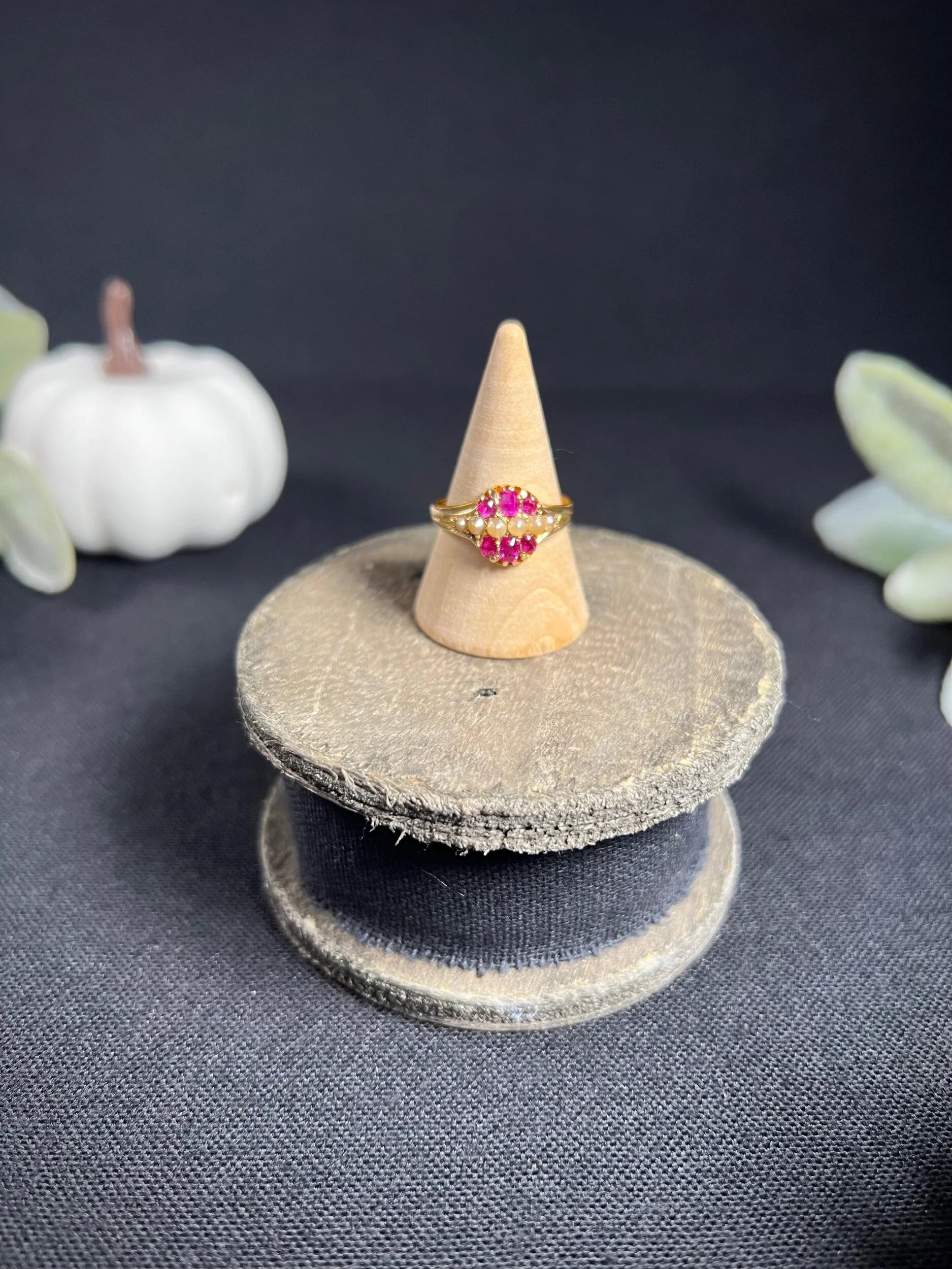 A yellow gold ruby and pearl cluster ring, on a ring cone