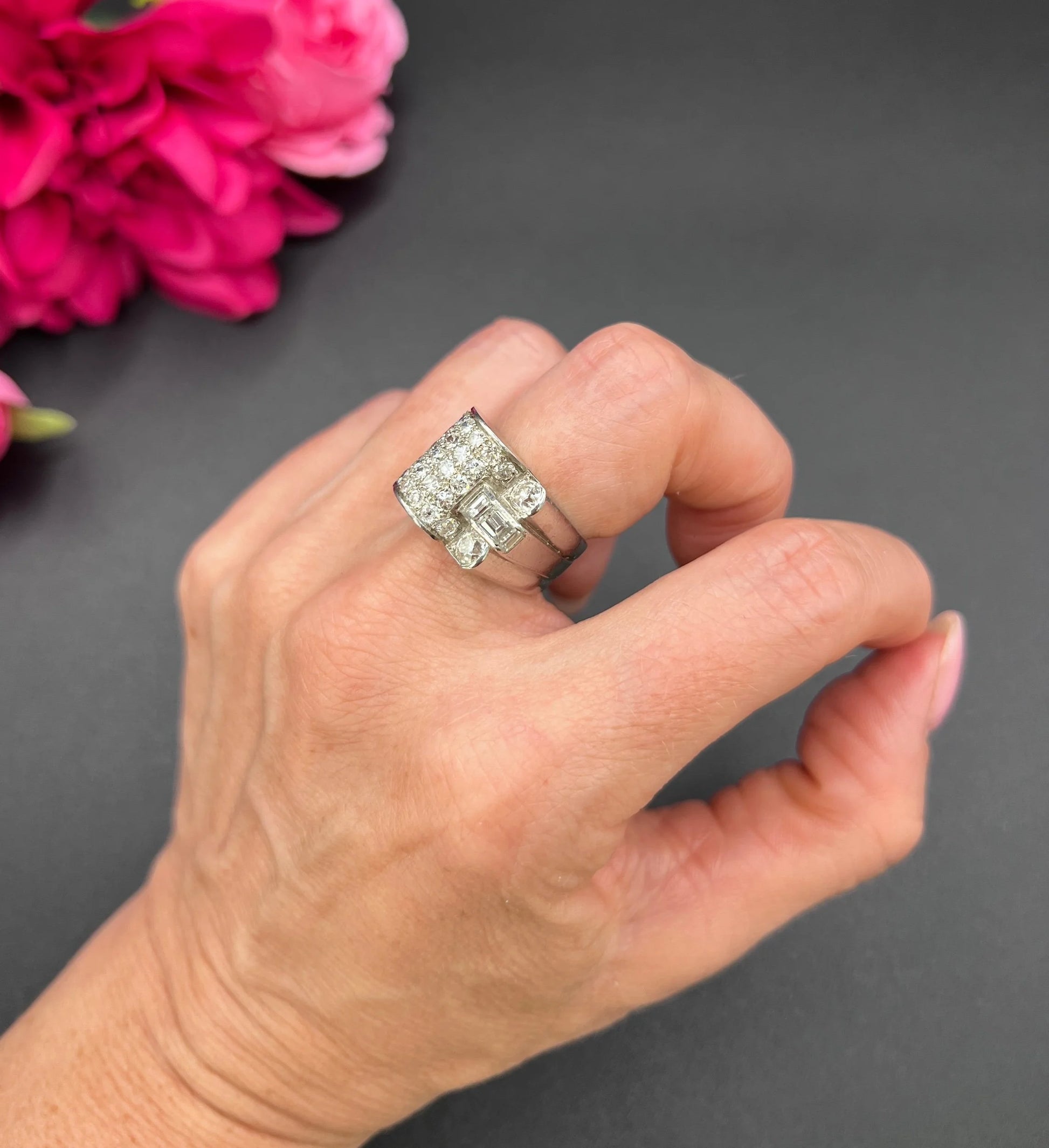 A round diamond tank style cocktail ring in platinum, modelled on a hand