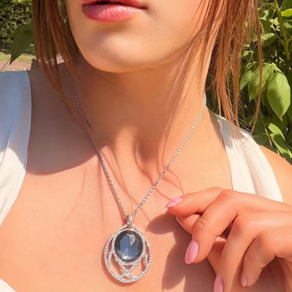 A dark crystal and white diamond pendant with a white gold chain, modelled by a woman