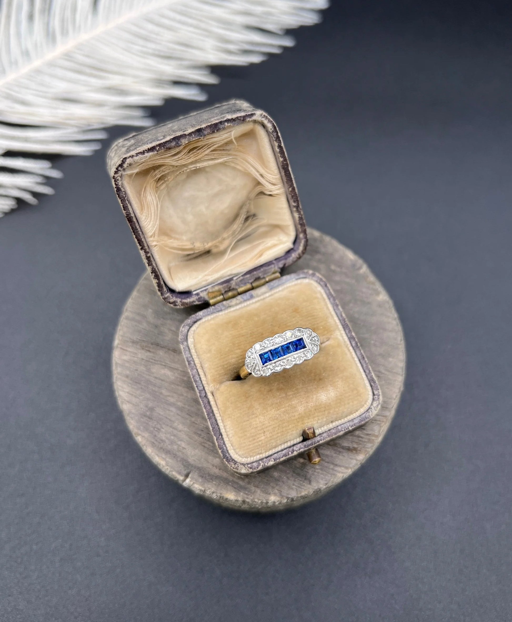 A sapphire and diamond elongated cluster ring in platinum and yellow gold, in an antique ring box