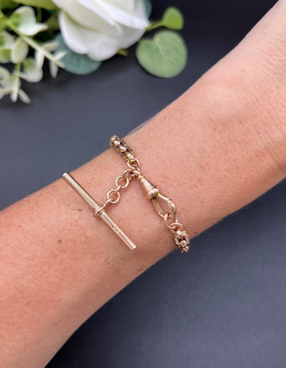 A fancy link rose gold bracelet with a T-bar and dog clip clasp, modelled on a wrist