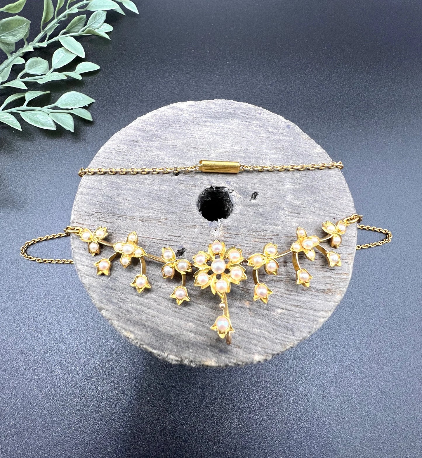 A yellow gold floral pendant necklace with seed pearls