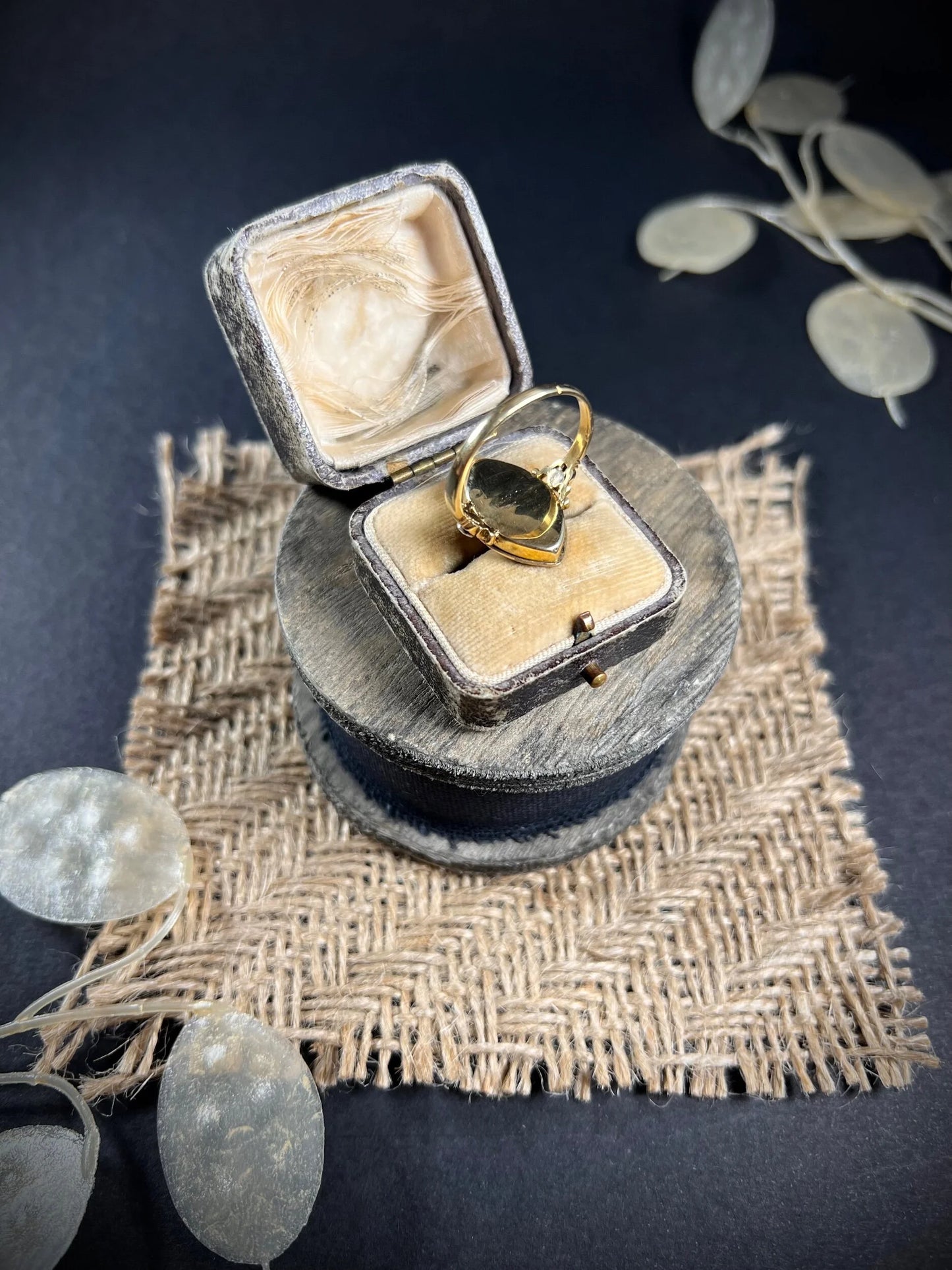 An ornate diamond and enamel navette shaped antique ring, in an antique ring box