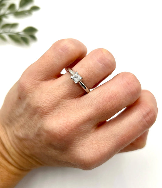A princess cut diamond solitaire ring in platinum, modelled on a hand