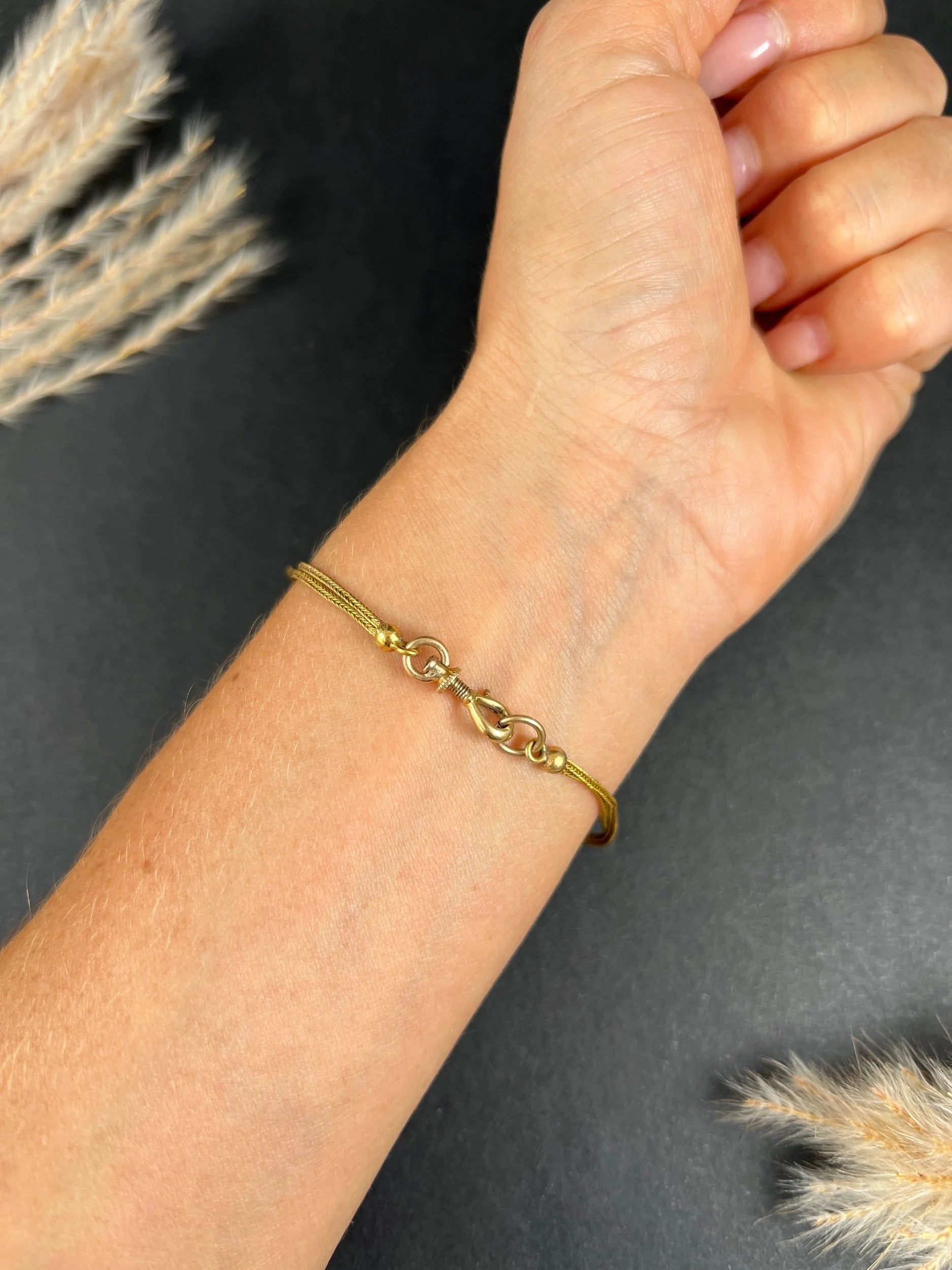 A yellow gold double row bracelet with black enamel tubular beads, modelled on a wrist