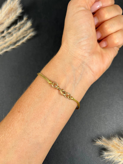 A yellow gold double row bracelet with black enamel tubular beads, modelled on a wrist