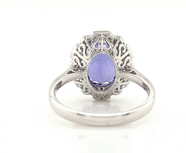 Tanzanite and Diamond Cluster Dress Ring; central 4.56 carat oval faceted tanzanite with brilliant and baguette-cut diamond surround, in 18ct white gold