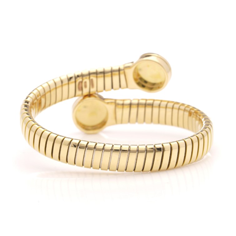 Vintage Bvlgari 18ct Yellow Gold and Onyx Tubogas Bangle Bracelet, 18ct yellow gold tubogas flexible sprung cuff made of coiled gas pipe links with terminals of circular onyx plaques encased in a polished surround engraved with the BVLGARI BVLGARI motif. Made in Italy, Alexandria, Circa 1990s