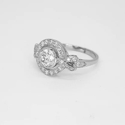 Diamond and Platinum Cluster Dress Ring; central 0.75 carat round brilliant-cut diamond surrounded by diamond halo border and diamond set shoulders, 1.10 carat total