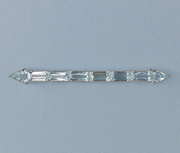 Art Deco Aquamarine Arrow Bar Brooch; baguette-cut and diamond-shaped aquamarines mounted in platinum, arrow design, on a yellow gold pin.