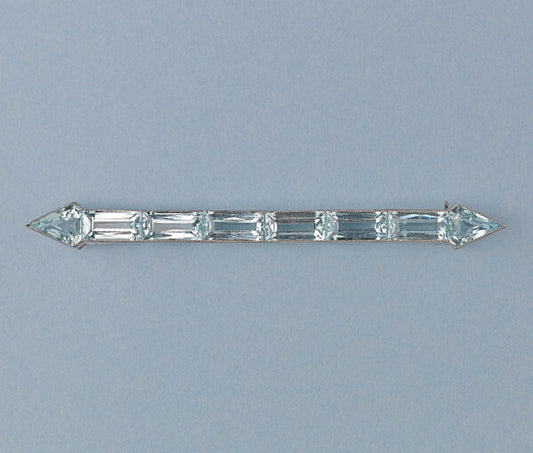 Art Deco Aquamarine Arrow Bar Brooch; baguette-cut and diamond-shaped aquamarines mounted in platinum, arrow design, on a yellow gold pin.